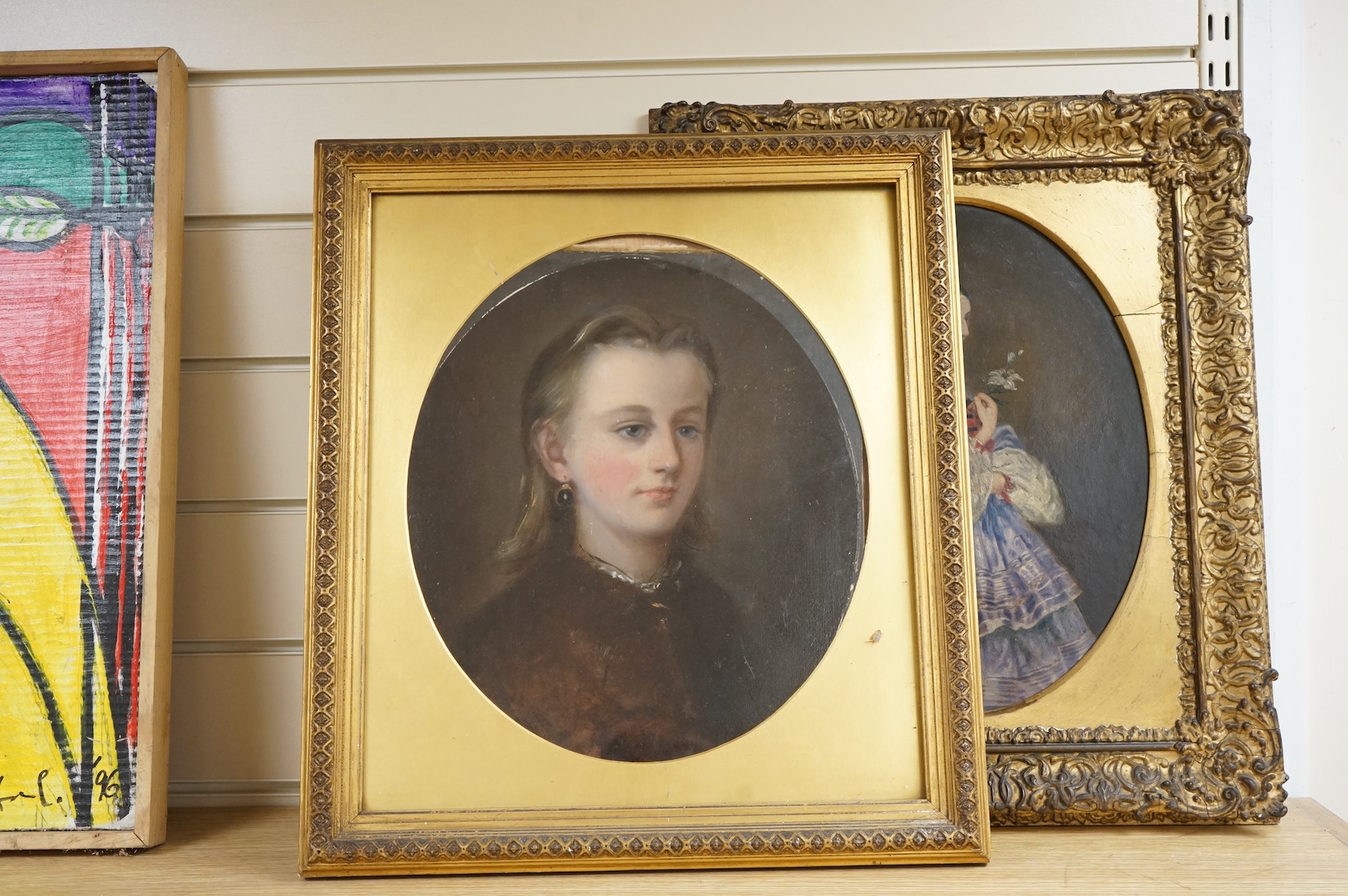 19th century, Naïve school, oval oil on board, three quarter length portrait of a lady, gilt framed, together with a similar portrait of a girl wearing garnet earrings, largest 34 x 24cm